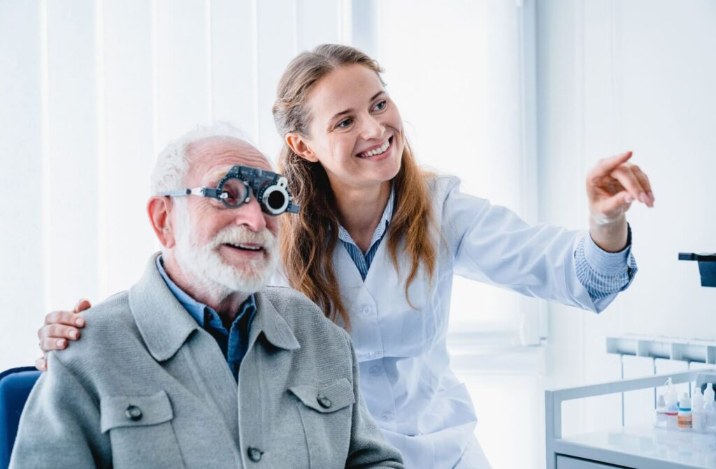 A smiling female optometrist helping an older male patient with his vision.