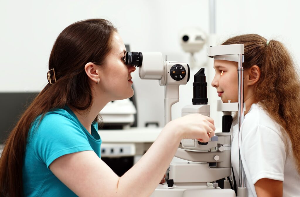 An optometrist looking at a child's eye through a slit lamp.